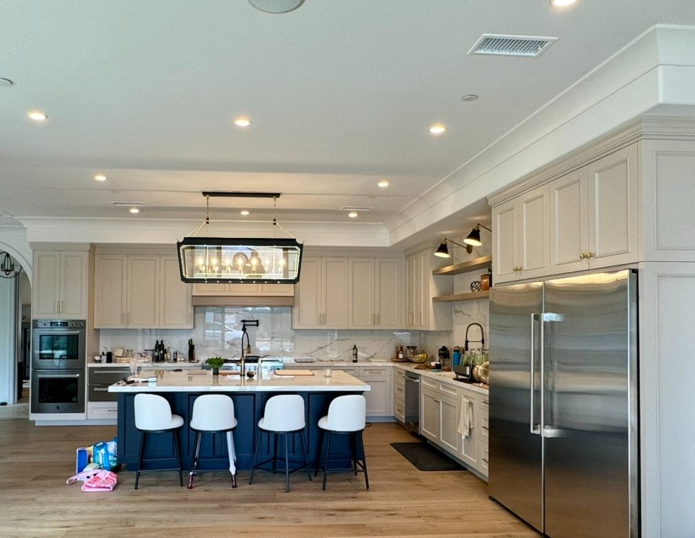 Bright white kitchen with navy island after repaint