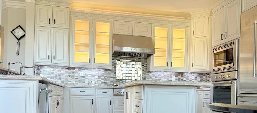 Glass-front upper cabinets with warm interior lighting