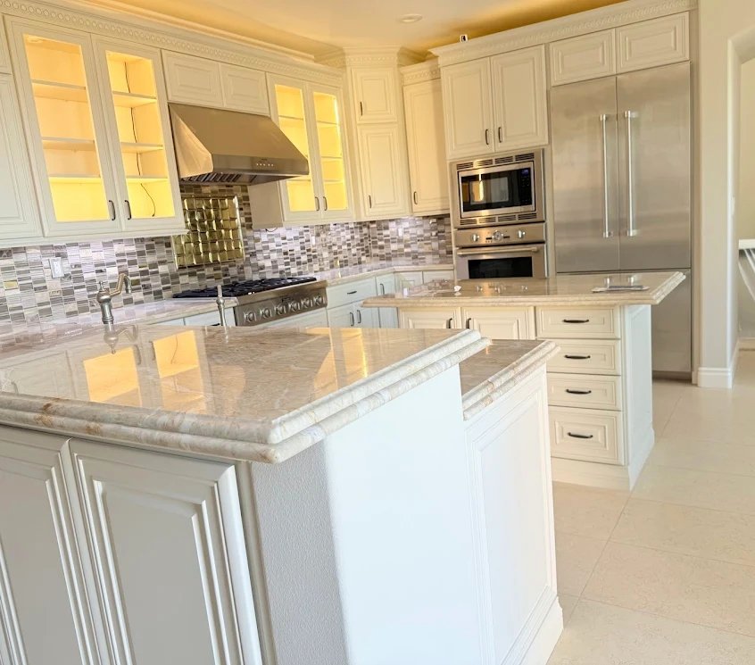Custom white kitchen with glass cabinets and marble island